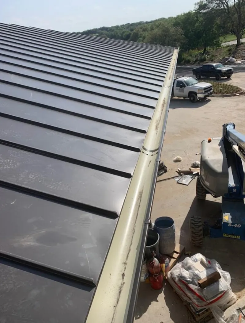 Standing seam panel and gutter detail on a metal roofing jobsite in Fair Oaks